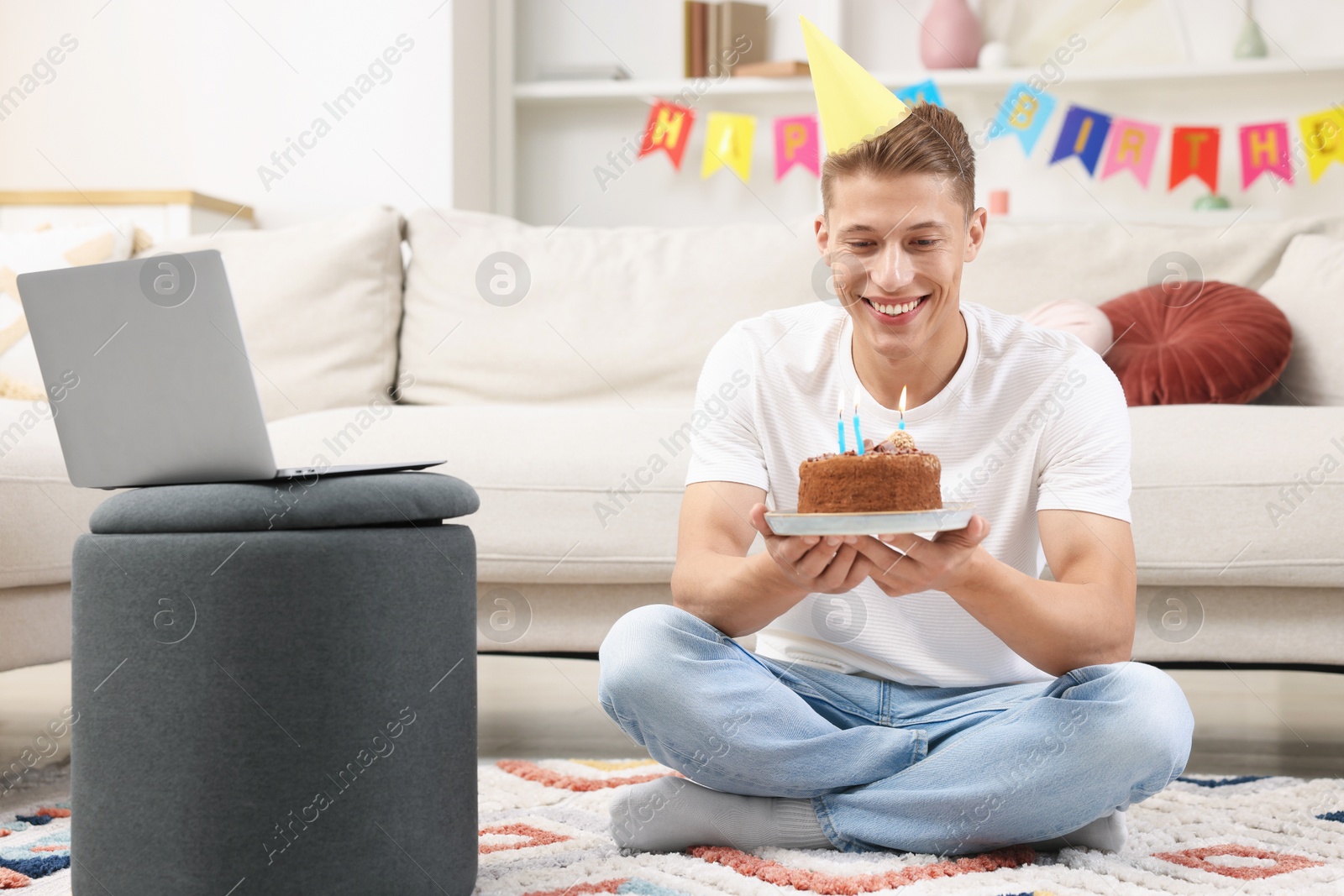 Man with cake celebrating his birthday and having video call via laptop at home Photo of Man with cake celebrating his birthday and having video call via laptop at home