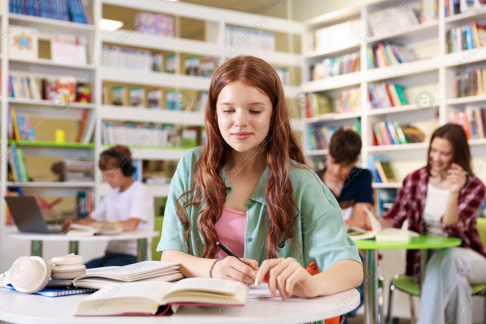 Student with books studying at table in library Photo of Student with books studying at table in library