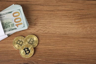 Photo of Cryptocurrency. Bitcoins and dollars on wooden table, flat lay. Space for text