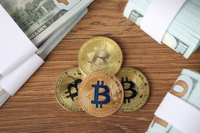 Photo of Cryptocurrency. Bitcoins and dollar banknotes on wooden table, flat lay