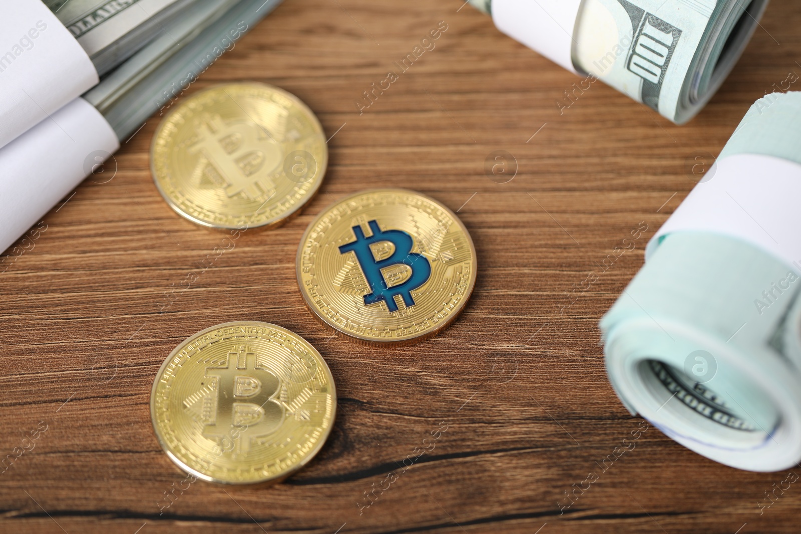 Photo of Cryptocurrency. Bitcoins and dollar banknotes on wooden table, above view