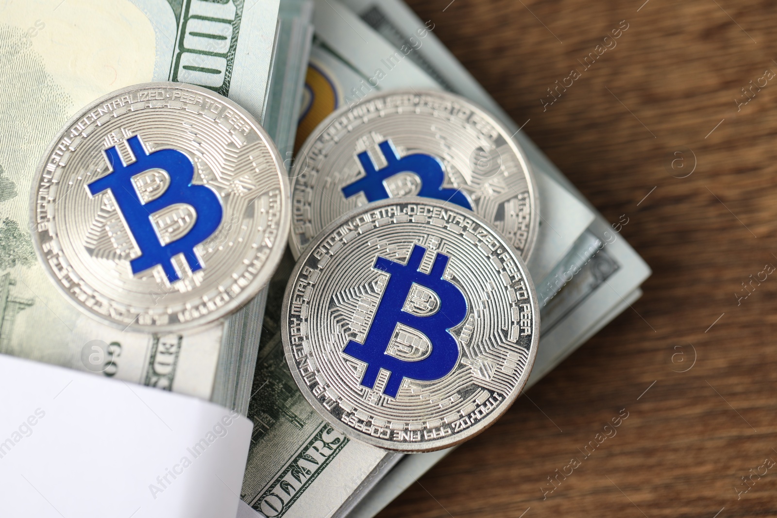 Photo of Cryptocurrency. Bitcoins and dollar banknotes on wooden table, top view