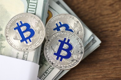 Photo of Cryptocurrency. Bitcoins and dollar banknotes on wooden table, top view