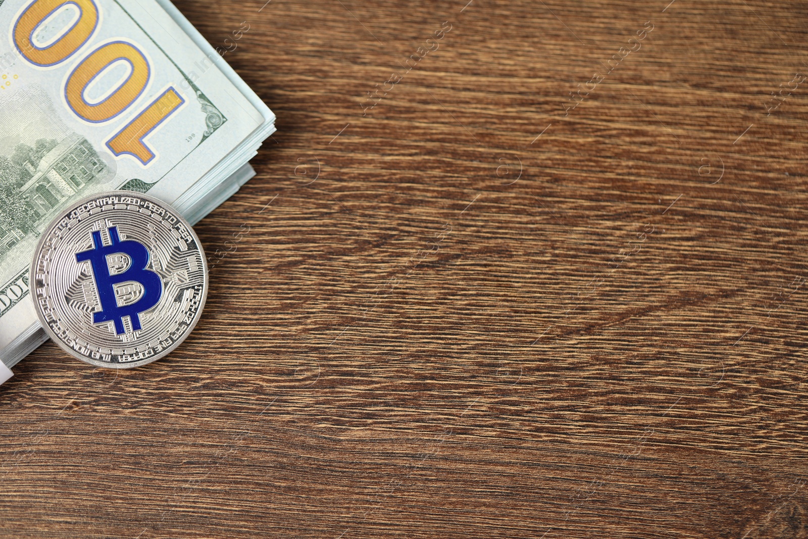 Photo of Cryptocurrency. Bitcoins and dollar banknotes on wooden table, top view. Space for text