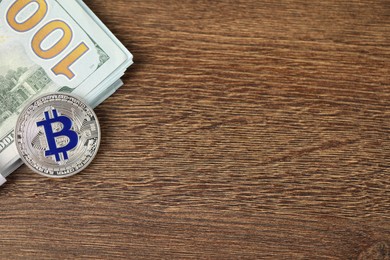 Photo of Cryptocurrency. Bitcoins and dollar banknotes on wooden table, top view. Space for text