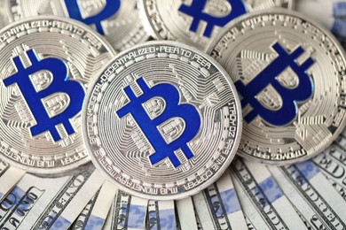 Photo of Cryptocurrency. Bitcoins on dollar banknotes, flat lay