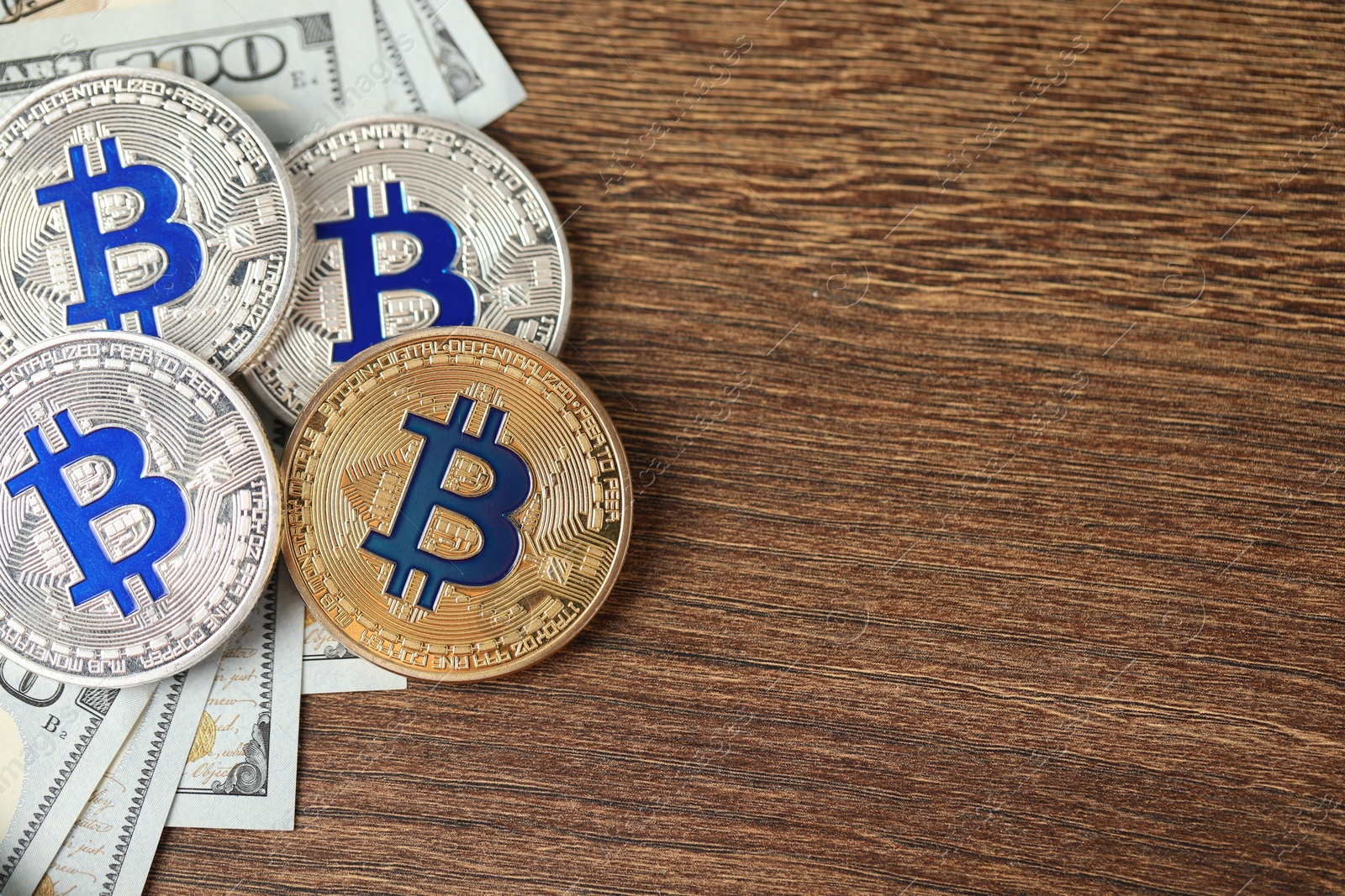Cryptocurrency. Bitcoins and dollars on wooden table, flat lay. Space for text Photo of Cryptocurrency. Bitcoins and dollars on wooden table, flat lay. Space for text
