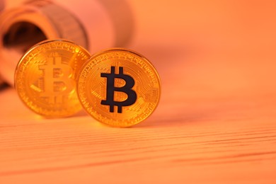 Photo of Cryptocurrency. Bitcoins and dollar banknotes on wooden table, closeup. Space for text