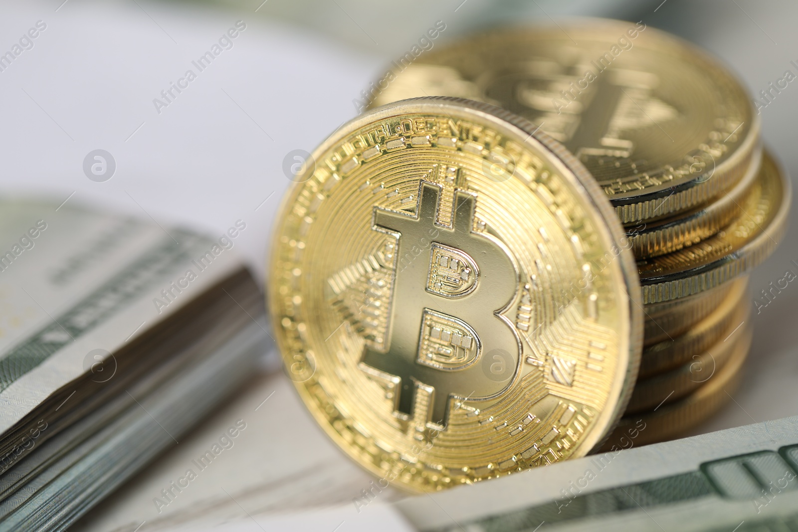 Photo of Cryptocurrency. Bitcoins and dollar banknotes on table, closeup