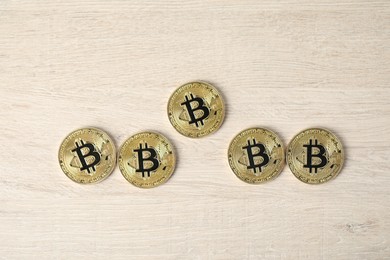 Photo of Cryptocurrency. Bitcoins on wooden table, flat lay