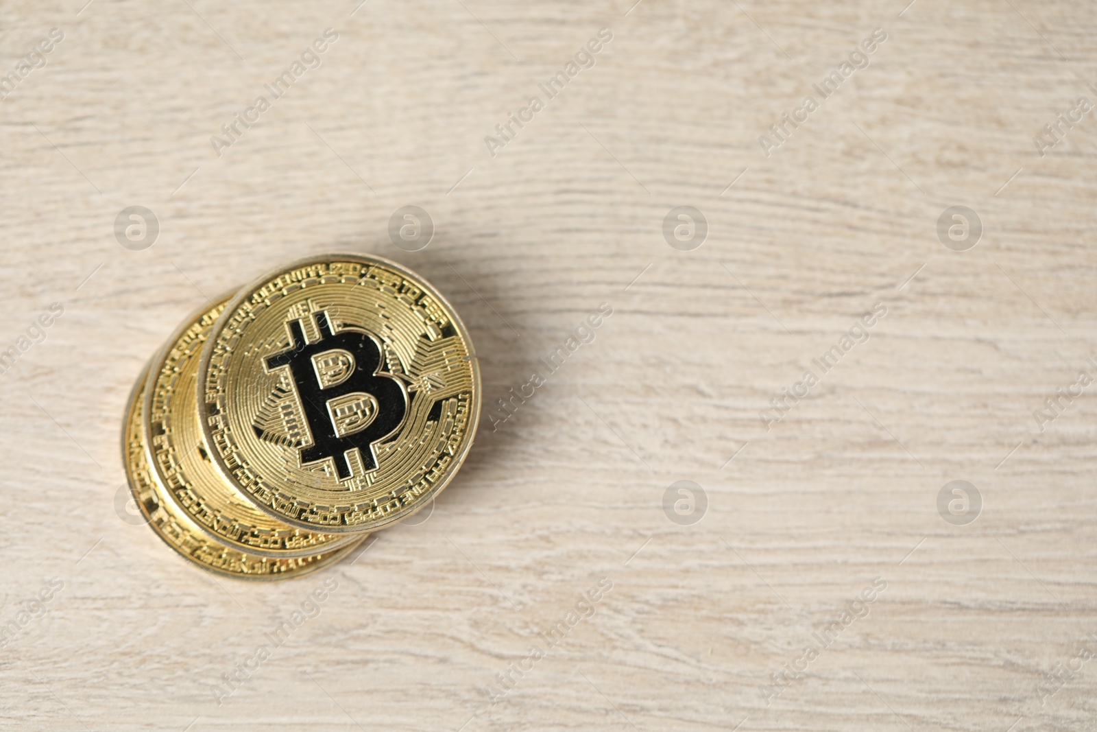 Cryptocurrency. Bitcoins on wooden table, top view. Space for text Photo of Cryptocurrency. Bitcoins on wooden table, top view. Space for text