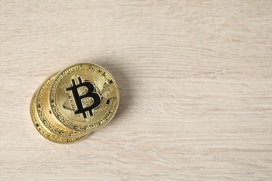 Photo of Cryptocurrency. Bitcoins on wooden table, top view. Space for text