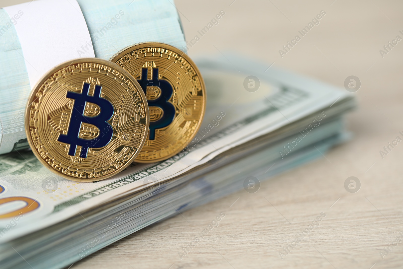Photo of Cryptocurrency. Bitcoins and dollar banknotes on wooden table, closeup. Space for text
