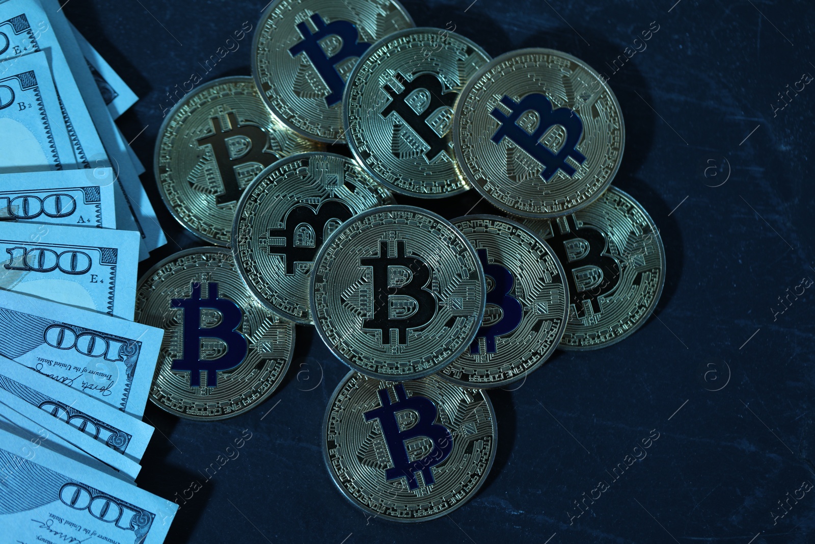 Photo of Cryptocurrency. Bitcoins and dollar banknotes on black table, flat lay