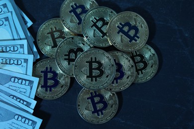 Photo of Cryptocurrency. Bitcoins and dollar banknotes on black table, flat lay