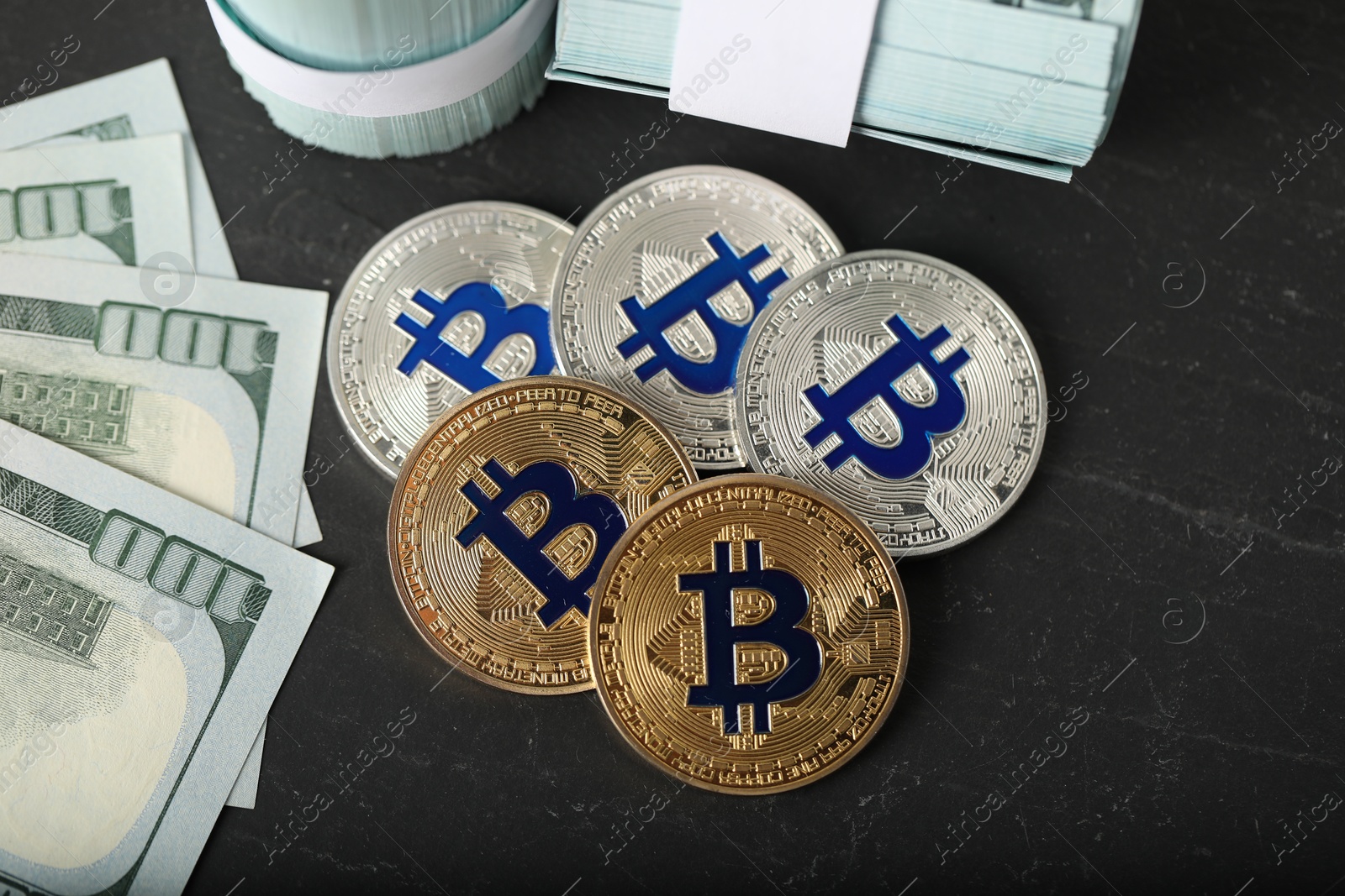 Photo of Cryptocurrency. Bitcoins and dollar banknotes on black table, flat lay