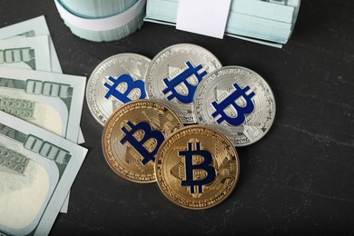 Photo of Cryptocurrency. Bitcoins and dollar banknotes on black table, flat lay