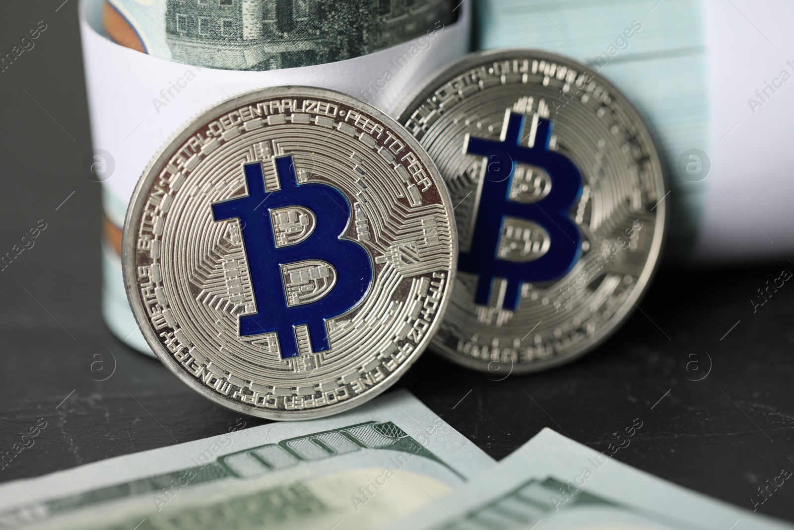 Photo of Cryptocurrency. Bitcoins and dollar banknotes on black table, closeup