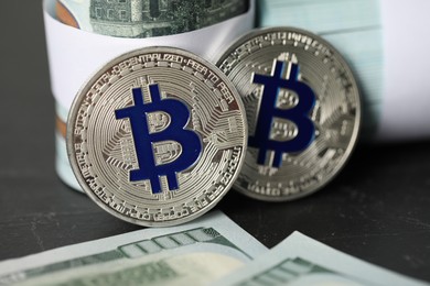 Photo of Cryptocurrency. Bitcoins and dollar banknotes on black table, closeup