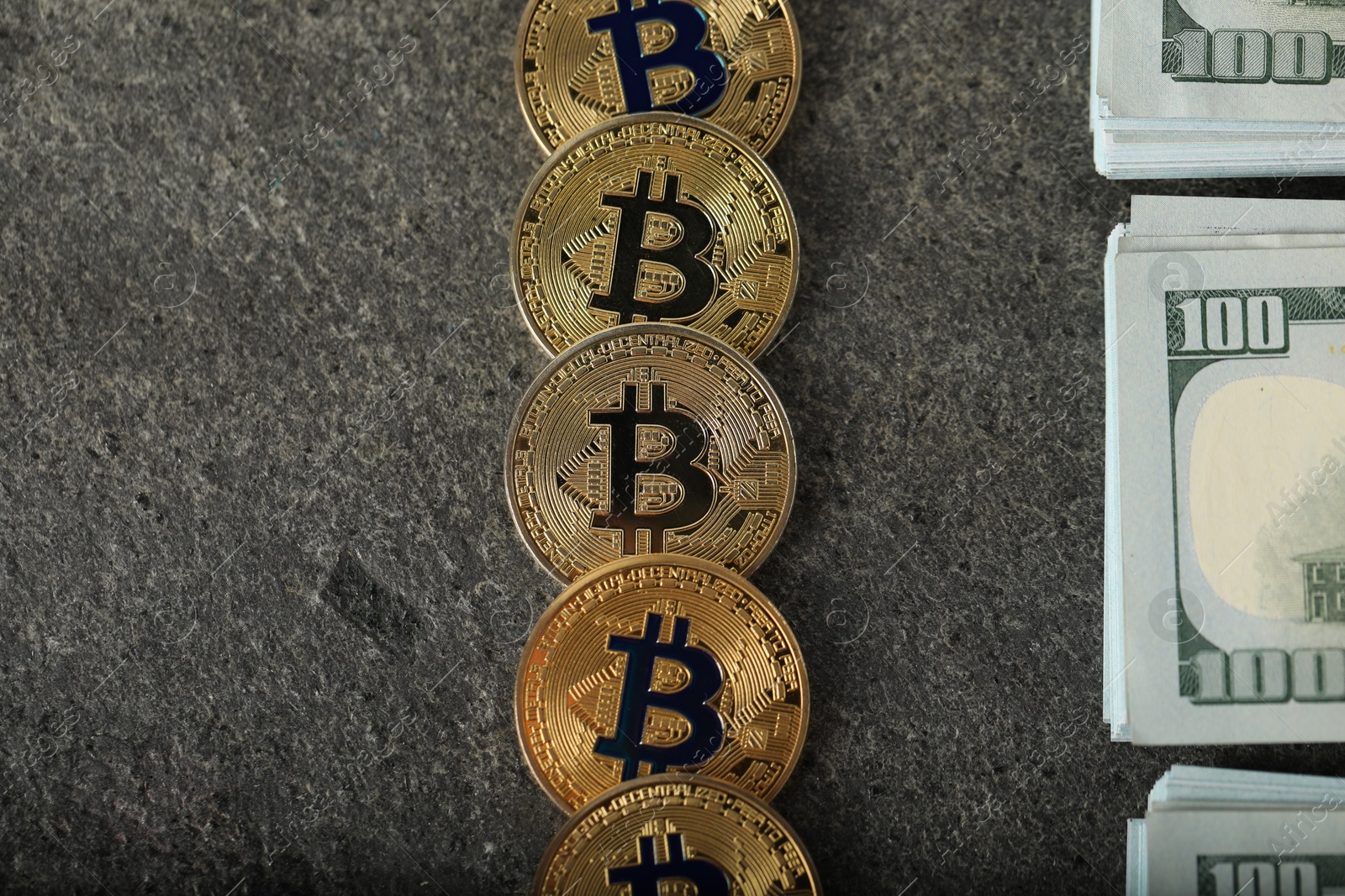 Photo of Cryptocurrency. Bitcoins and dollar banknotes on grey table, flat lay
