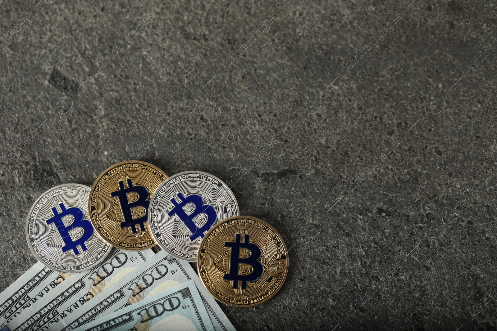 Cryptocurrency. Bitcoins and dollars on grey table, flat lay. Space for text Photo of Cryptocurrency. Bitcoins and dollars on grey table, flat lay. Space for text