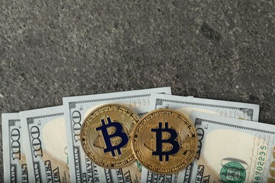Photo of Cryptocurrency. Bitcoins and dollars on grey table, flat lay. Space for text
