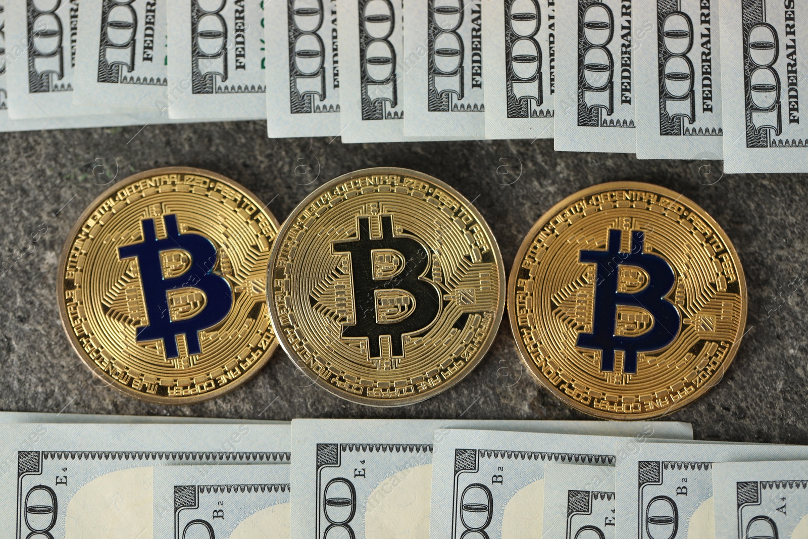 Photo of Cryptocurrency. Bitcoins and dollar banknotes on grey table, flat lay