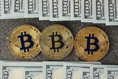 Photo of Cryptocurrency. Bitcoins and dollar banknotes on grey table, flat lay