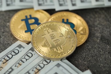 Photo of Cryptocurrency. Bitcoins and dollar banknotes on grey table, closeup