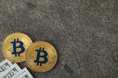 Photo of Cryptocurrency. Bitcoins and dollars on grey table, flat lay. Space for text