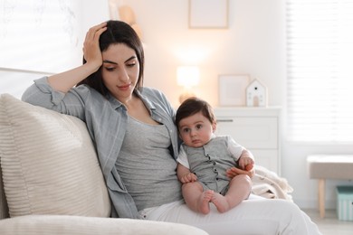 Photo of Woman suffering from postpartum depression with her little baby on sofa at home. Space for text