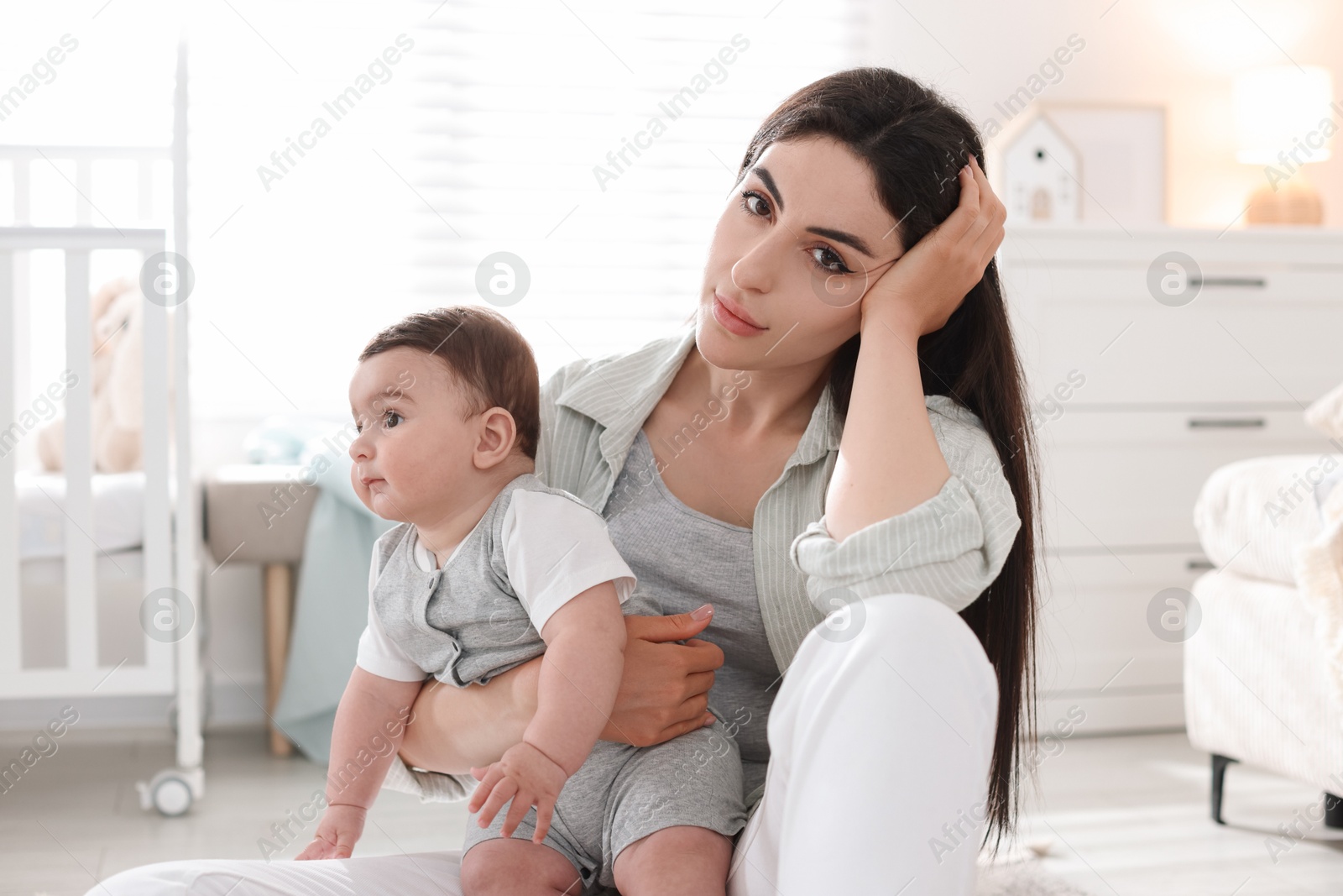 Photo of Woman suffering from postpartum depression with her little baby at home