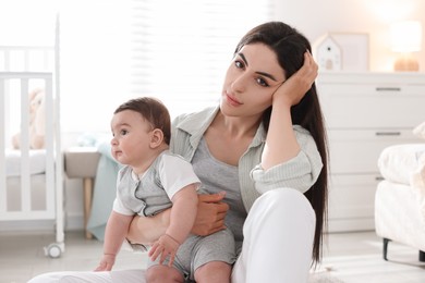 Photo of Woman suffering from postpartum depression with her little baby at home