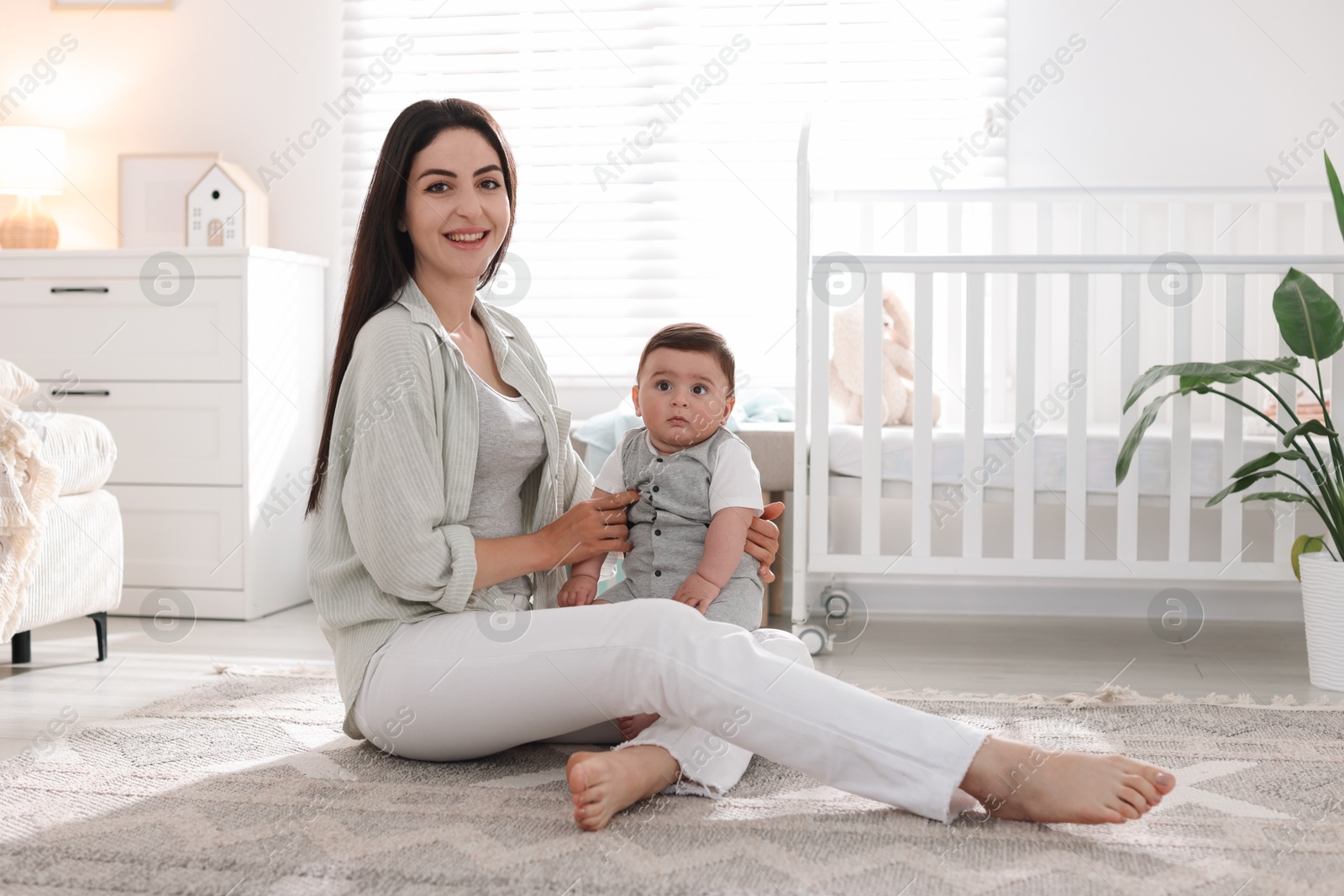 Mother with her cute baby at home. Space for text Photo of Mother with her cute baby at home. Space for text