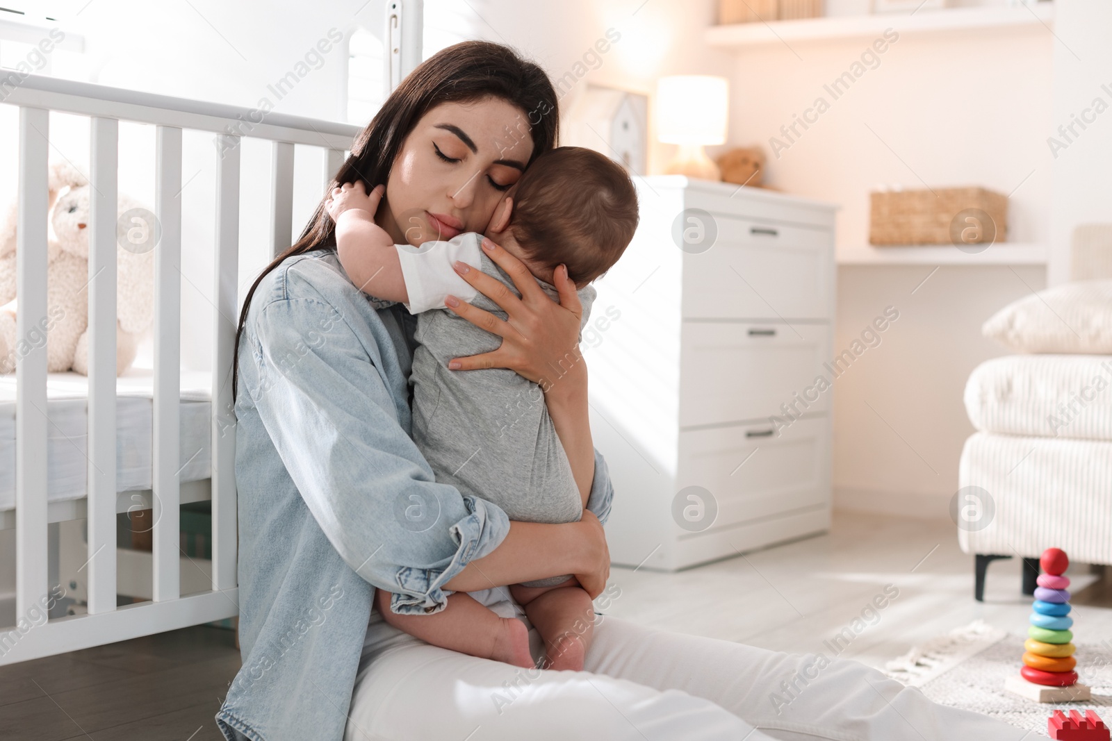 Woman suffering from postpartum depression with her little baby at home. Space for text Photo of Woman suffering from postpartum depression with her little baby at home. Space for text