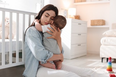 Photo of Woman suffering from postpartum depression with her little baby at home. Space for text