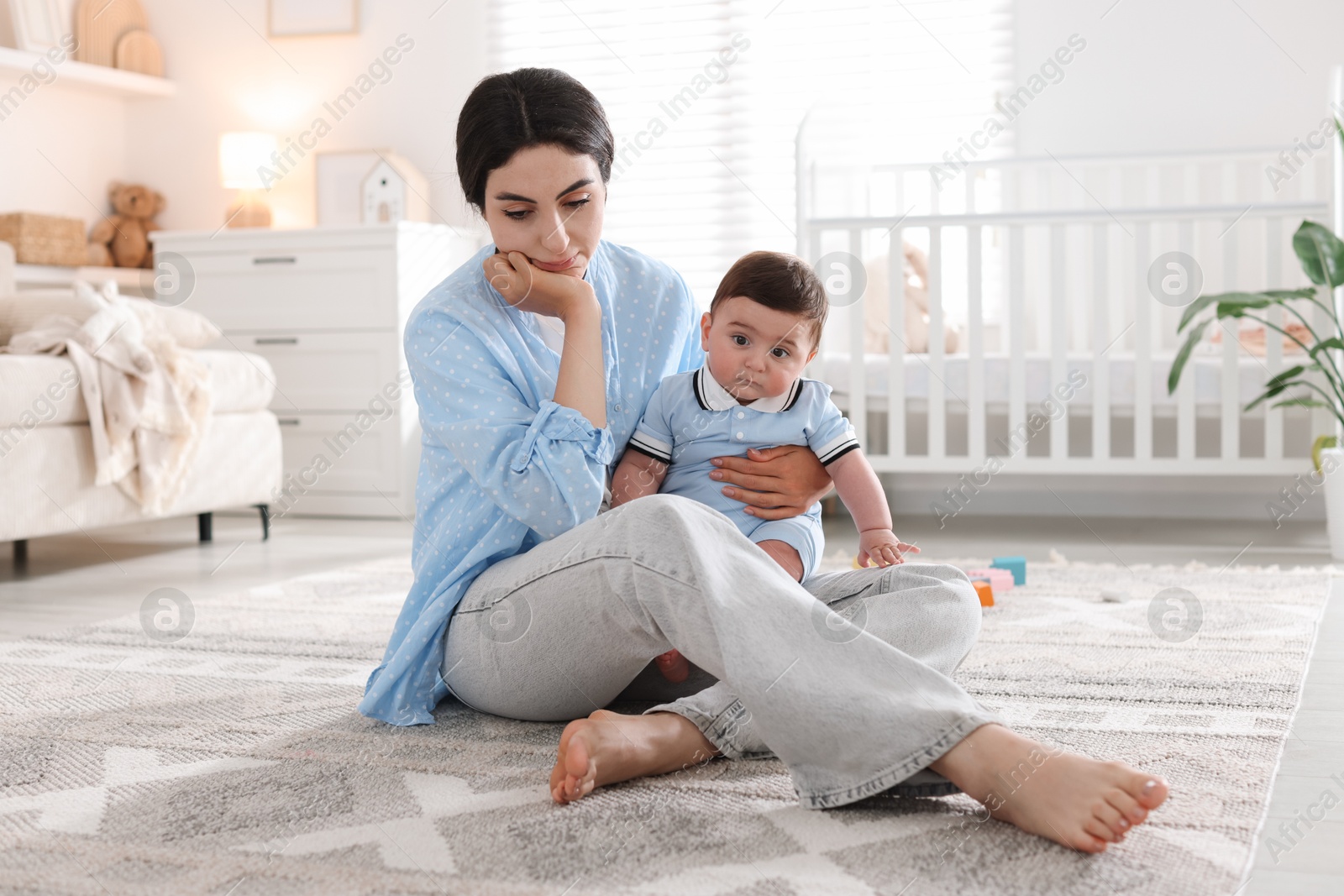 Woman suffering from postpartum depression with her little baby at home Photo of Woman suffering from postpartum depression with her little baby at home