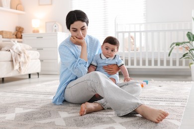 Photo of Woman suffering from postpartum depression with her little baby at home