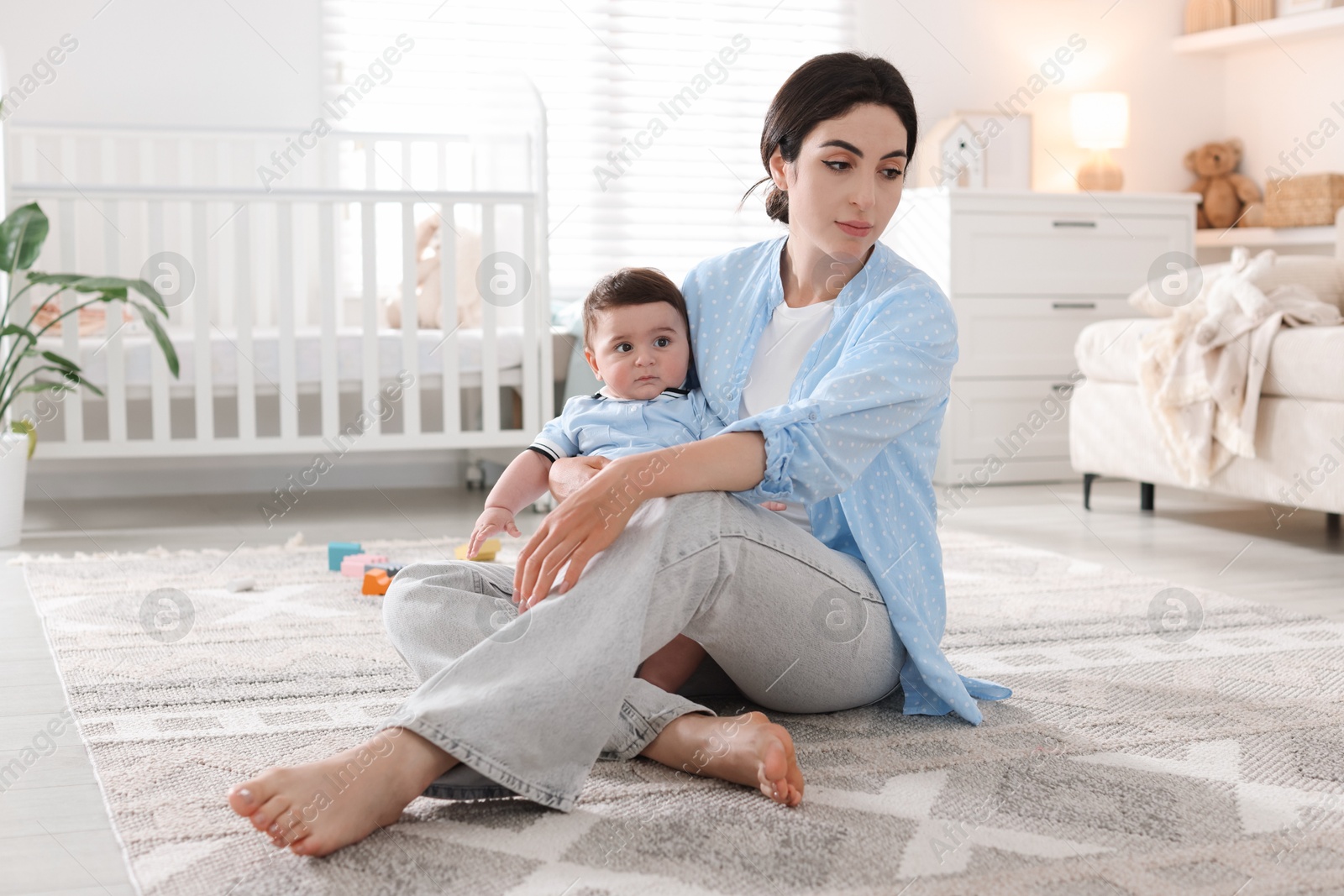 Woman suffering from postpartum depression with her little baby at home Photo of Woman suffering from postpartum depression with her little baby at home