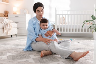 Photo of Woman suffering from postpartum depression with her little baby at home