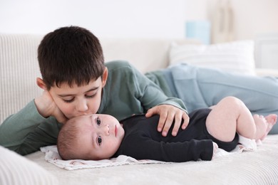 Photo of Cute little brothers on sofa at home
