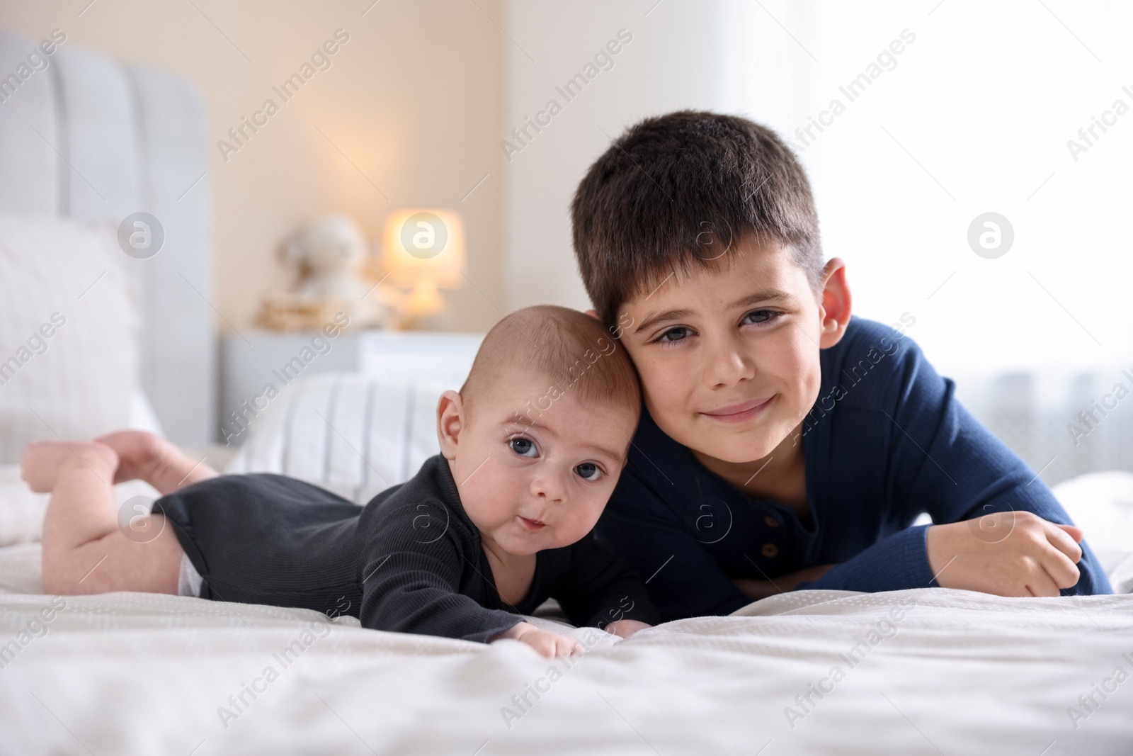 Cute little brothers on bed at home Photo of Cute little brothers on bed at home