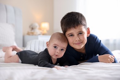 Photo of Cute little brothers on bed at home