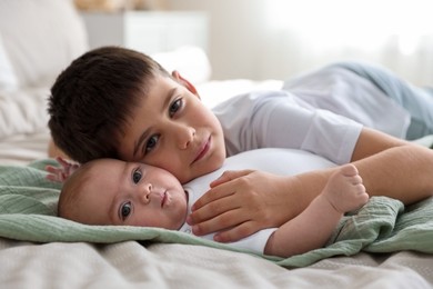 Photo of Cute little brothers on bed at home