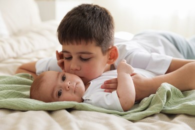 Photo of Cute little brothers on bed at home