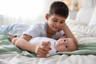 Photo of Cute little brothers on bed at home