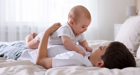 Photo of Cute little brothers on bed at home
