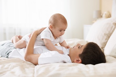 Photo of Cute little brothers on bed at home