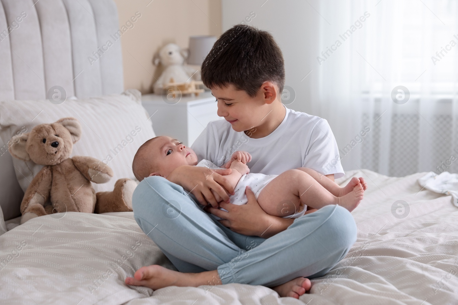 Cute little brothers on bed at home Photo of Cute little brothers on bed at home