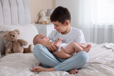 Photo of Cute little brothers on bed at home